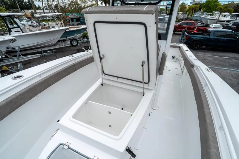 Slide: The Image of 2025 Sea Hunt Gamefish 28 CB boat with open storage compartment, docked among other boats. - 40