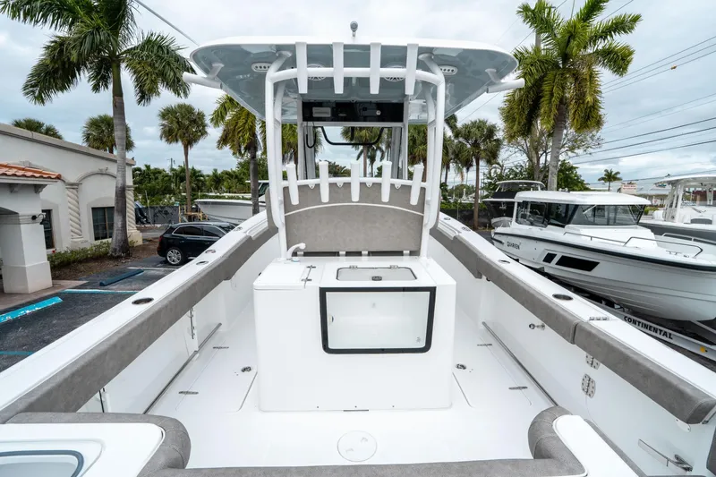 Slide: The Image of 2025 Sea Hunt Gamefish 28 CB boat interior with center console and palm trees in background. - 9