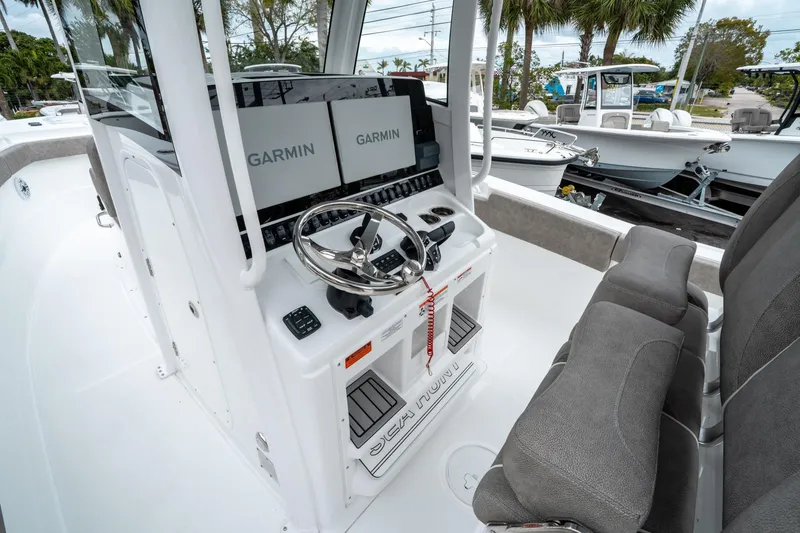 Slide: The Image of 2025 Sea Hunt Gamefish 28 CB boat interior with Garmin displays and steering wheel. - 27