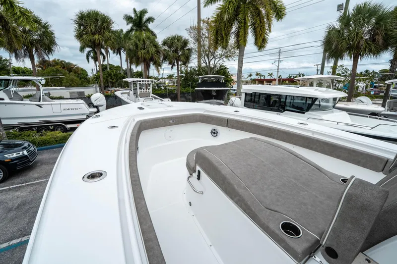 Slide: The Image of 2025 Sea Hunt Gamefish 28 CB boat with spacious seating, docked near palm trees. - 34