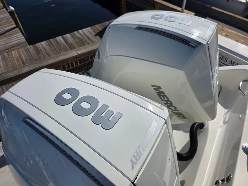 Slide: The Image of Twin Mercury outboard engines on a 2021 Blackwood 27 boat at a dock. - 10