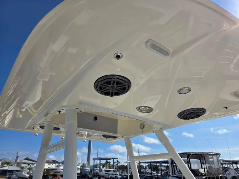 Slide: The Image of 2021 Blackwood 27 boat canopy with speakers and lights, docked under a clear blue sky. - 16