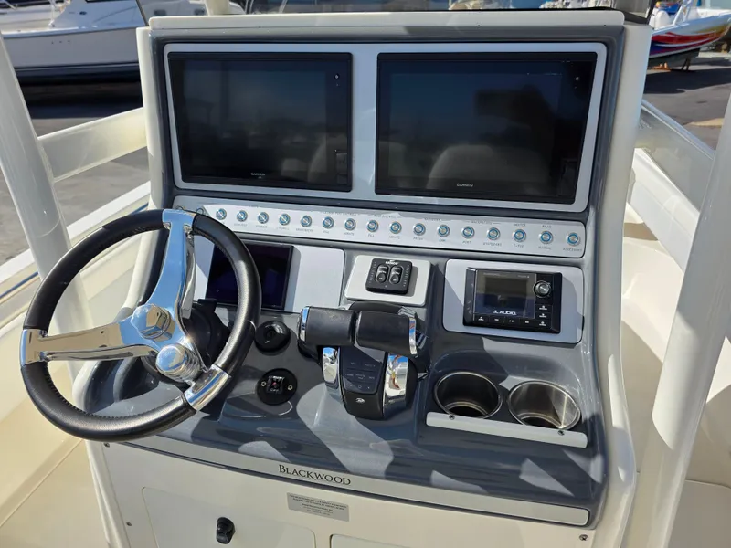 Slide: The Image of Control panel of a 2021 Blackwood 27 boat with dual screens and steering wheel. - 19
