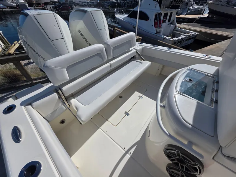 Slide: The Image of 2021 Blackwood 27 boat interior with seating and twin Mercury engines at a marina. - 25