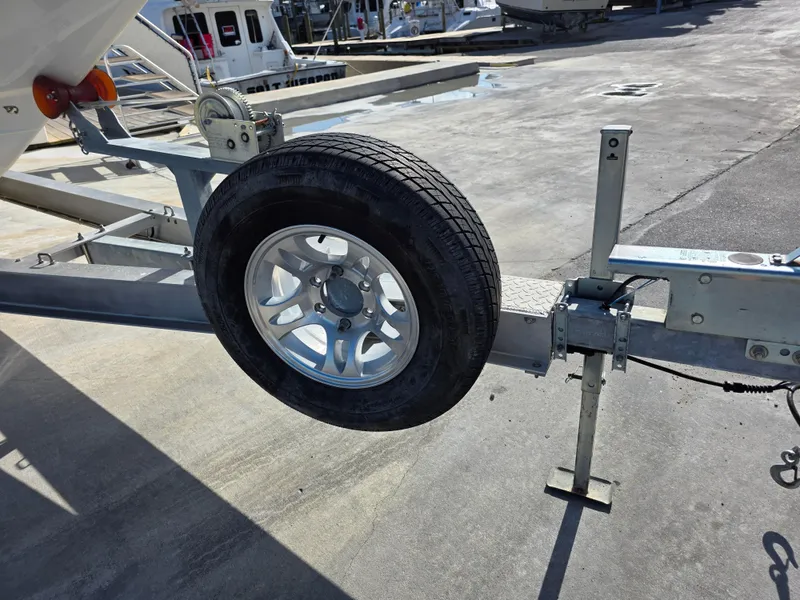Slide: The Image of Trailer wheel on a 2021 Blackwood 27 boat, parked on a concrete surface. - 28