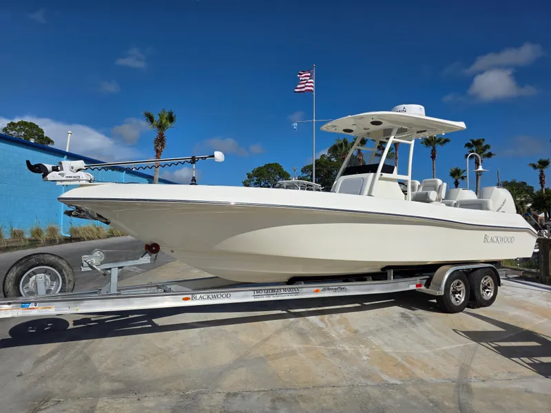 Slide: The Image of 2021 Blackwood 27 boat on trailer, clear sky, American flag in background. - 4