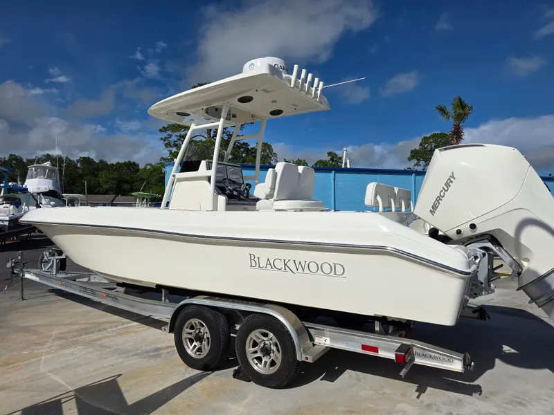 Slide: The Image of 2021 Blackwood 27 boat on trailer with Mercury engine, parked outdoors. - 5