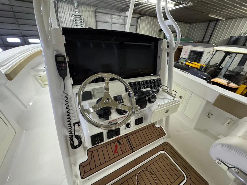 Slide: The Image of 2017 Southport 33 FE boat helm with steering wheel and control panel in a garage. - 19