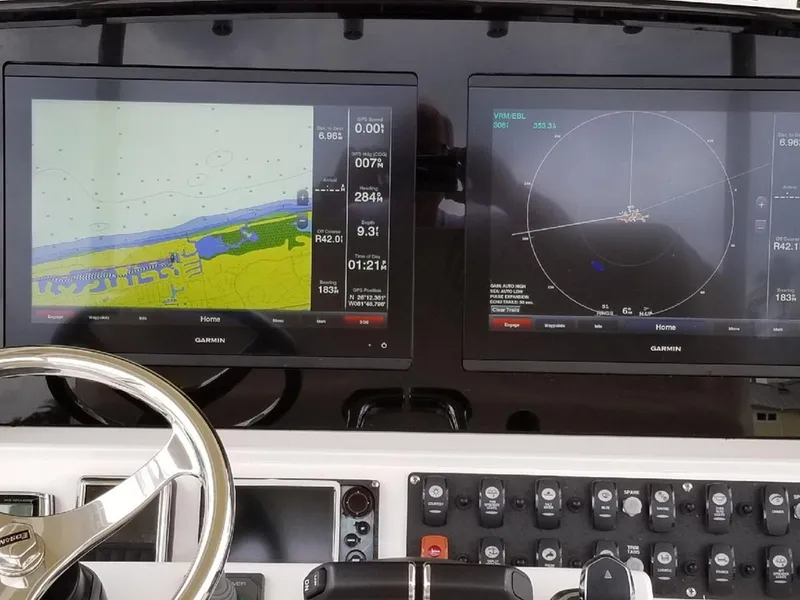 Slide: The Image of 2017 Southport 33 FE boat dashboard with dual Garmin navigation screens and control panel. - 20