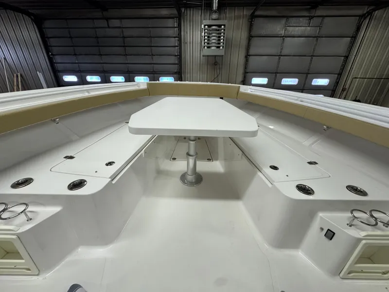 Slide: The Image of 2017 Southport 33 FE boat interior with seating and table in a garage. - 27