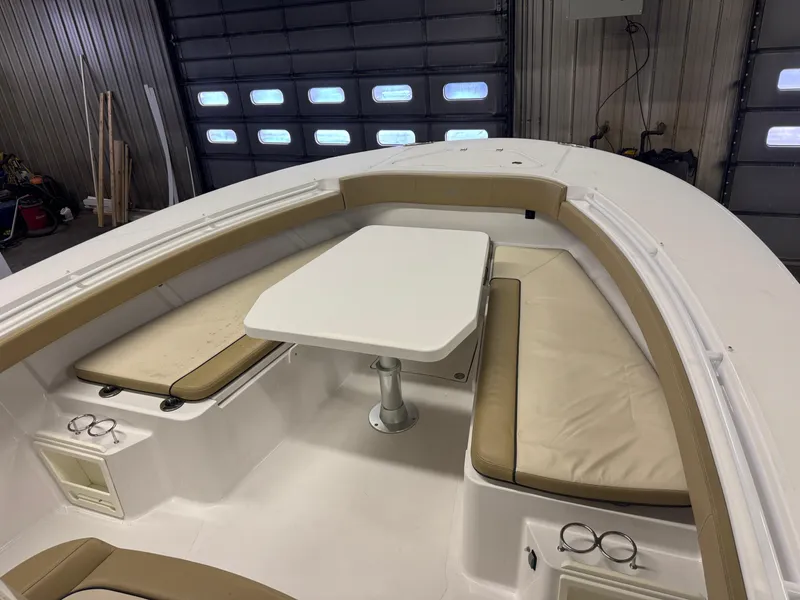 Slide: The Image of 2017 Southport 33 FE boat interior with cushioned seating and table in a garage. - 28