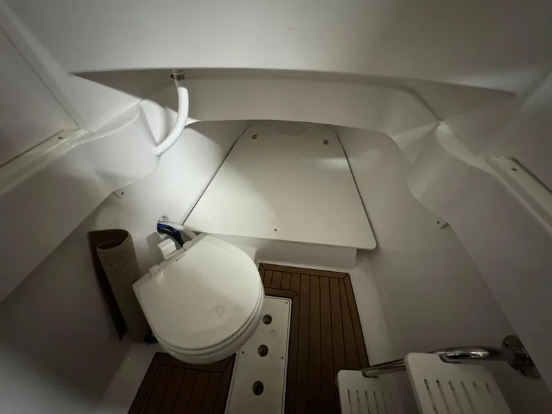 Slide: The Image of 2017 Southport 33 FE boat interior with toilet and wooden flooring. - 33