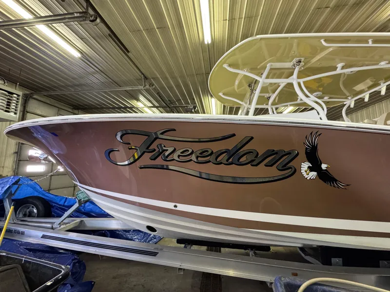 Slide: The Image of 2017 Southport 33 FE boat named "Freedom" with eagle graphic in a garage. - 39