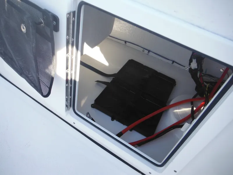 Slide: The Image of Storage compartment of 2025 Tidewater 180 CC Adventure boat with wiring and battery. - 23