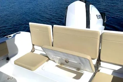Slide: The Image of 2019 Release 240 RX boat with beige seating and Evinrude outboard motor on blue water. - 3