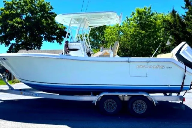 Slide: The Image of 2019 Release 240 RX boat on trailer, parked outdoors with trees in background. - 4