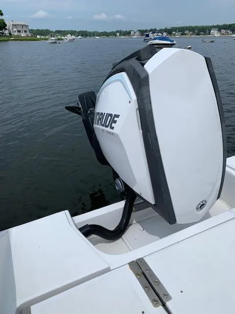 Slide: The Image of Boat with Evinrude outboard motor on a 2019 Release 240 RX, docked by a lake. - 6