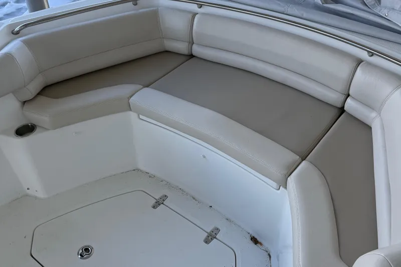Slide: The Image of 2016 Boston Whaler 330 Outrage boat seating area with beige cushions. - 10