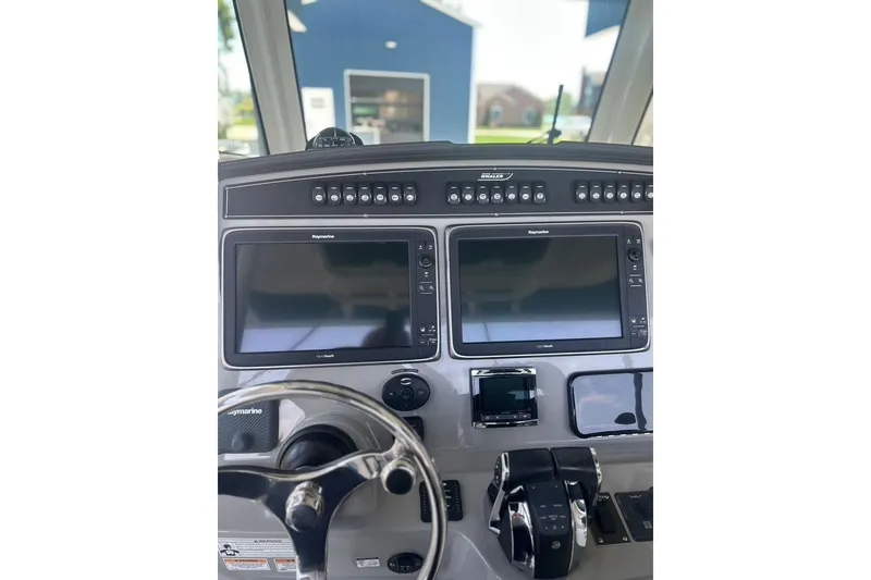 Slide: The Image of 2016 Boston Whaler 330 Outrage helm with dual Raymarine displays and controls. - 28
