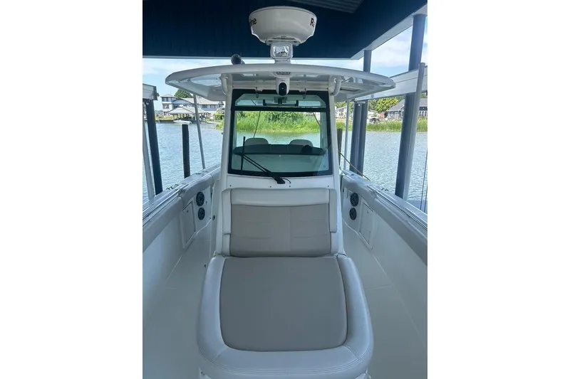 Slide: The Image of 2016 Boston Whaler 330 Outrage boat interior with seating, docked by the water. - 34