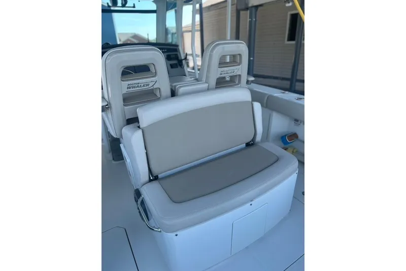 Slide: The Image of 2016 Boston Whaler 330 Outrage boat seating area with cushioned seats and storage. - 44