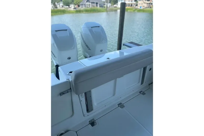 Slide: The Image of 2016 Boston Whaler 330 Outrage boat with dual Mercury engines, docked by a serene waterfront. - 47