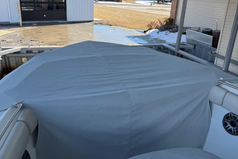 Slide: The Image of Covered 2016 Boston Whaler 330 Outrage boat docked, showcasing protective tarp and speakers. - 5