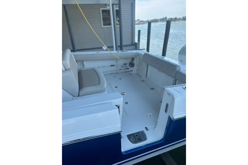 Slide: The Image of 2016 Boston Whaler 330 Outrage boat interior with seating, docked by the water. - 52