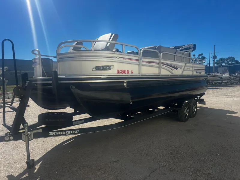 Slide: The Image of 2019 Ranger Reata 223F pontoon boat on trailer under clear blue sky. - 8