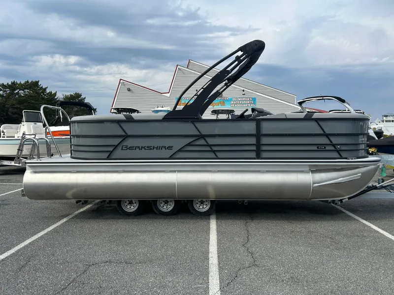Slide: The Image of 2025 Berkshire 22RFX ARCH CTS 2.75 pontoon boat parked on asphalt under cloudy sky. - 0