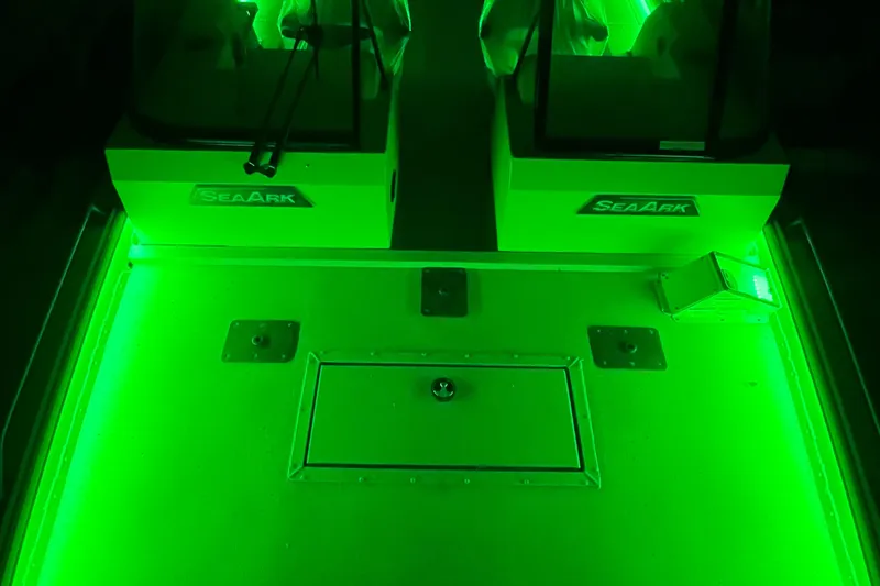 Slide: The Image of 2025 SeaArk ProCat 200 boat interior illuminated with vibrant green lighting. - 7