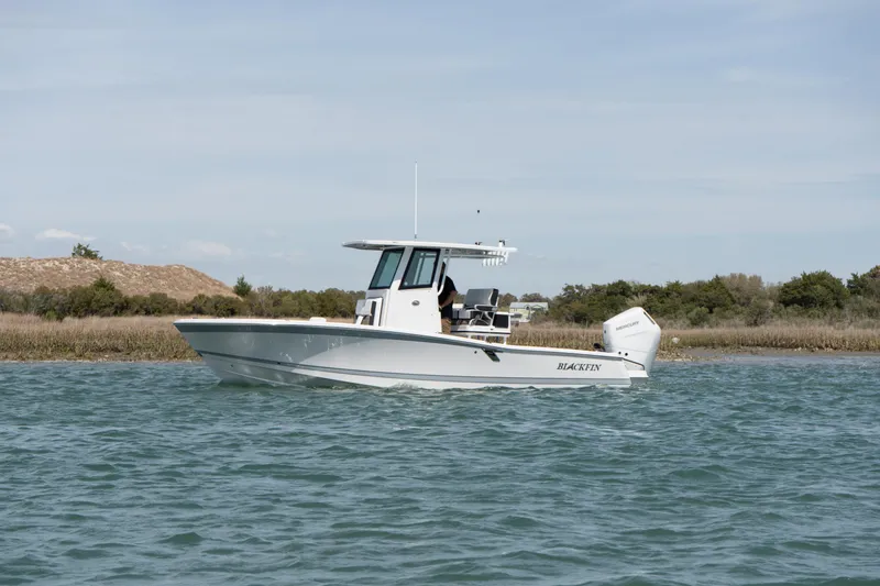 The Image of 2025 Blackfin 262 HB boat cruising on calm waters near a shoreline. - 0
