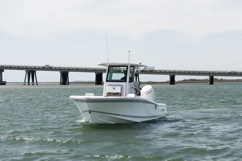 Slide: The Image of 2025 Blackfin 262 HB boat cruising on water near a bridge. - 2