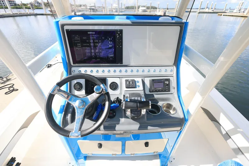 Slide: The Image of 2021 ShearWater 27 Carolina boat dashboard with steering wheel and navigation controls. - 10
