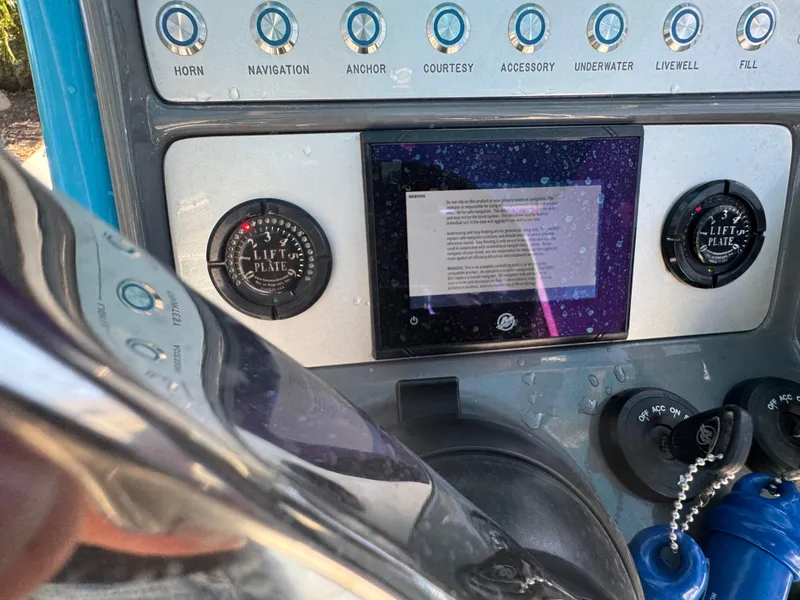 Slide: The Image of Control panel of a 2021 ShearWater 27 Carolina boat with various switches and gauges. - 16