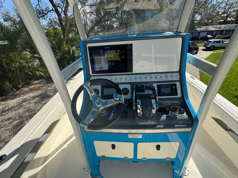 Slide: The Image of 2021 ShearWater 27 Carolina boat dashboard with steering wheel and navigation controls. - 17