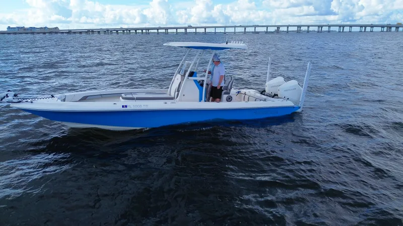 Slide: The Image of 2021 ShearWater 27 Carolina boat on open water with bridge in background. - 2