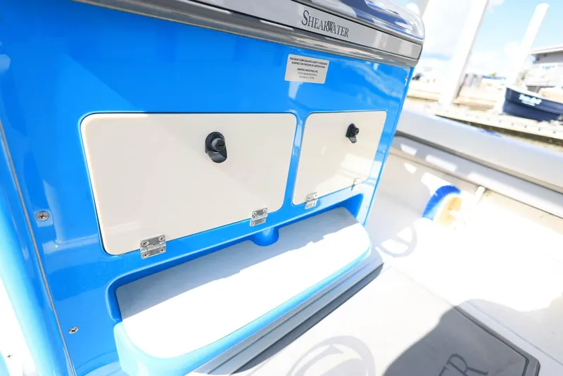Slide: The Image of 2021 ShearWater 27 Carolina boat interior with blue and white storage compartments. - 36