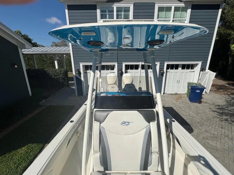 Slide: The Image of 2021 ShearWater 27 Carolina boat with T-top, parked in front of a modern house. - 41