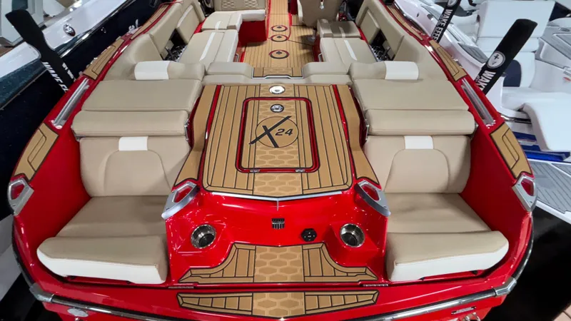Slide: The Image of 2025 MasterCraft X24 boat interior with beige seating and red accents. - 14