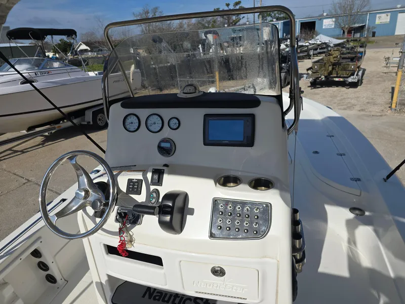 Slide: The Image of 2016 NauticStar 227 XTS boat dashboard with steering wheel and navigation controls. - 5