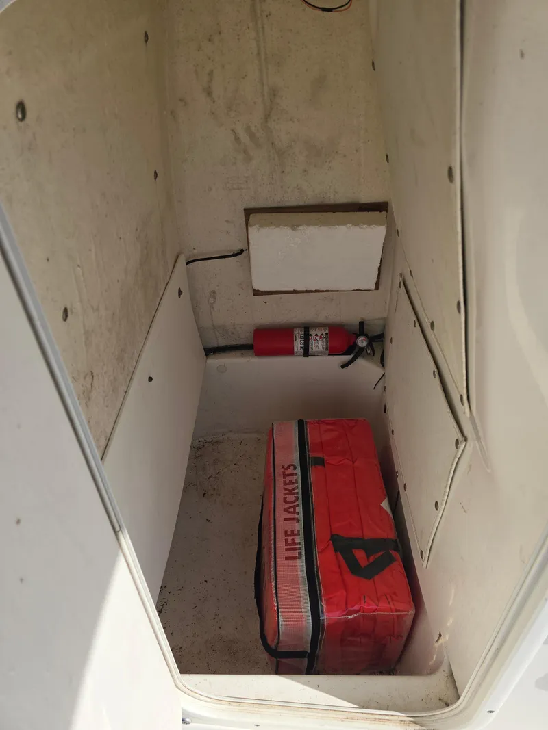 Slide: The Image of Storage compartment of 2016 NauticStar 227 XTS with fire extinguisher and red bag. - 9