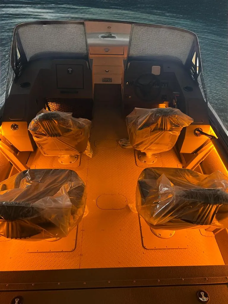 Slide: The Image of 2025 SeaArk Protege boat interior with illuminated seating and protective covers. - 4