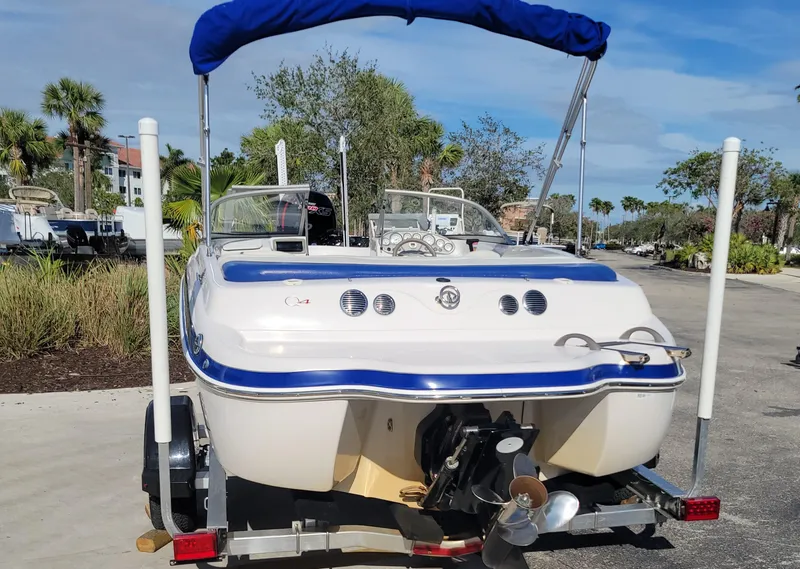 Slide: The Image of 2007 Tahoe Q4 L boat with blue canopy on trailer, parked outdoors. - 3