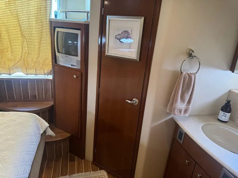 Slide: The Image of Interior of 2005 Meridian 459 Motoryacht with TV, bed, and bathroom amenities. - 18