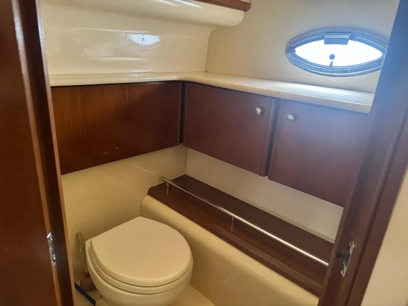 Slide: The Image of 2005 Meridian 459 Motoryacht bathroom with wooden cabinets and oval window. - 20