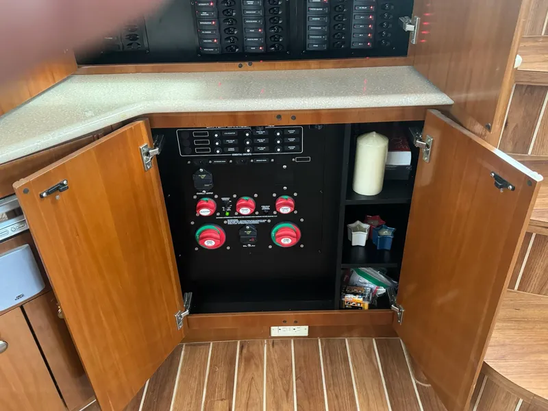 Slide: The Image of Electrical panel inside a 2005 Meridian 459 Motoryacht with open wooden cabinet doors. - 23