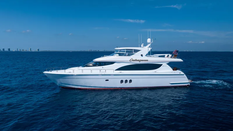 The Image of 2005 Hatteras 80 Motor Yacht cruising on open sea under clear blue sky. - 0