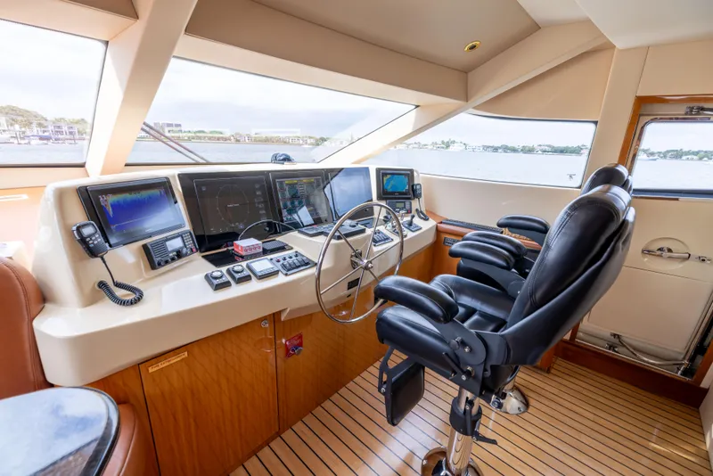 Slide: The Image of Helm of 2005 Hatteras 80 Motor Yacht with modern navigation equipment and leather seating. - 23