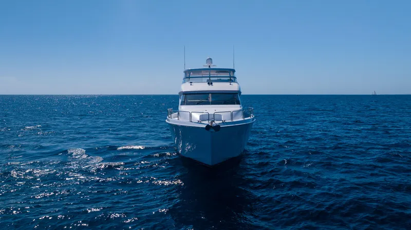 Slide: The Image of 2005 Hatteras 80 Motor Yacht cruising on open sea under clear blue sky. - 6